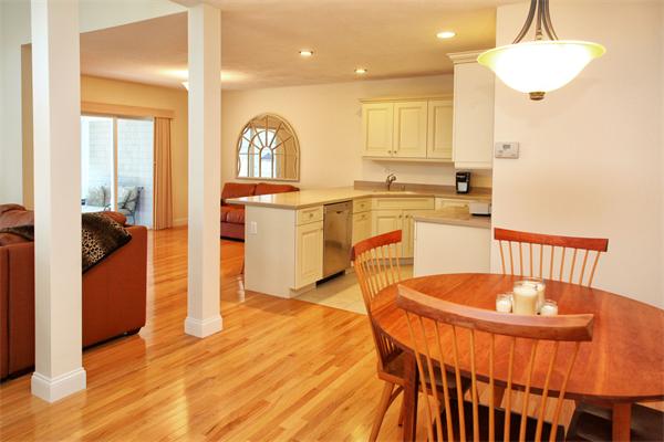 48 Turnberry Road, Unit 48 Bourne, MA 02532 - Photo 5 of 20 a kitchen with stainless steel appliances granite countertop a stove a sink a refrigerator and a dining table with wooden floor