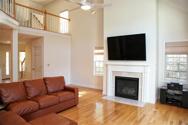 48 Turnberry Road, Unit 48 Bourne, MA 02532 - Photo 8 of 20 a living room with furniture a fireplace and a flat screen tv