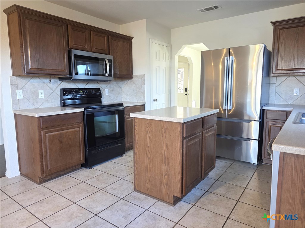 2203 Riley Drive Killeen, TX 76542 - Photo 7 of 22 a kitchen with stainless steel appliances granite countertop a stove a refrigerator and a microwave