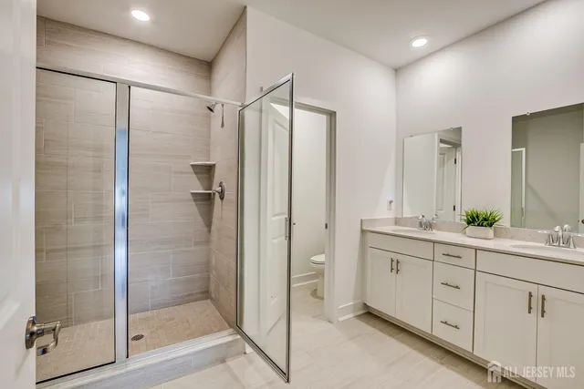 a bathroom with a double vanity sink toilet and shower