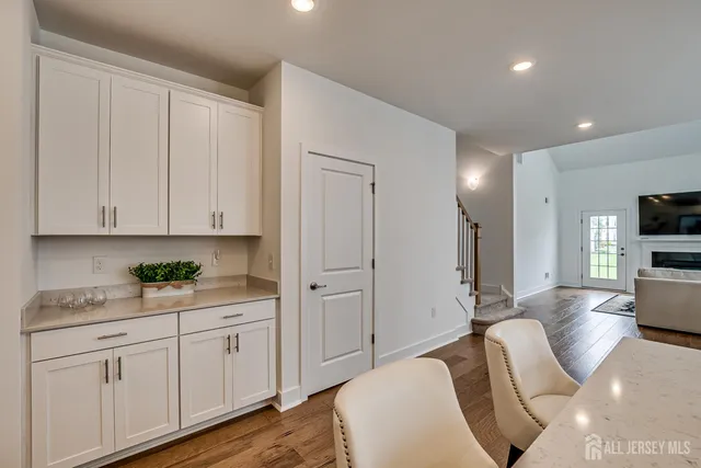 a living room with furniture a flat screen tv and kitchen view