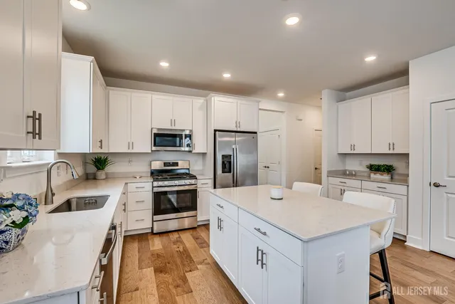 a kitchen with white cabinets and stainless steel appliances