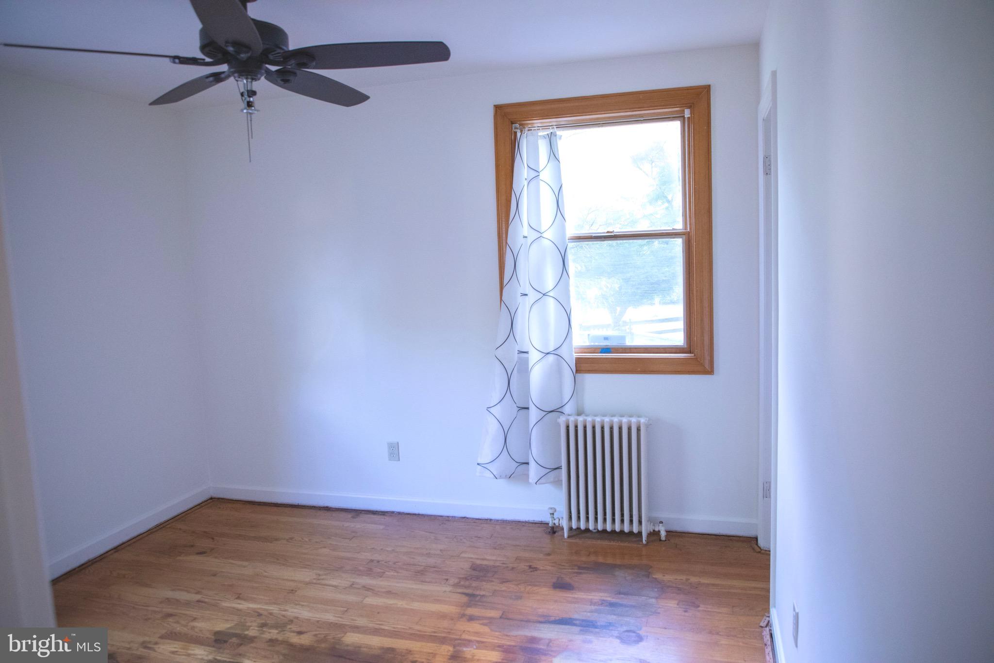 9406 Seminole Street Silver Spring, MD 20901 - Photo 16 of 32 an empty room with wooden floor fan and windows