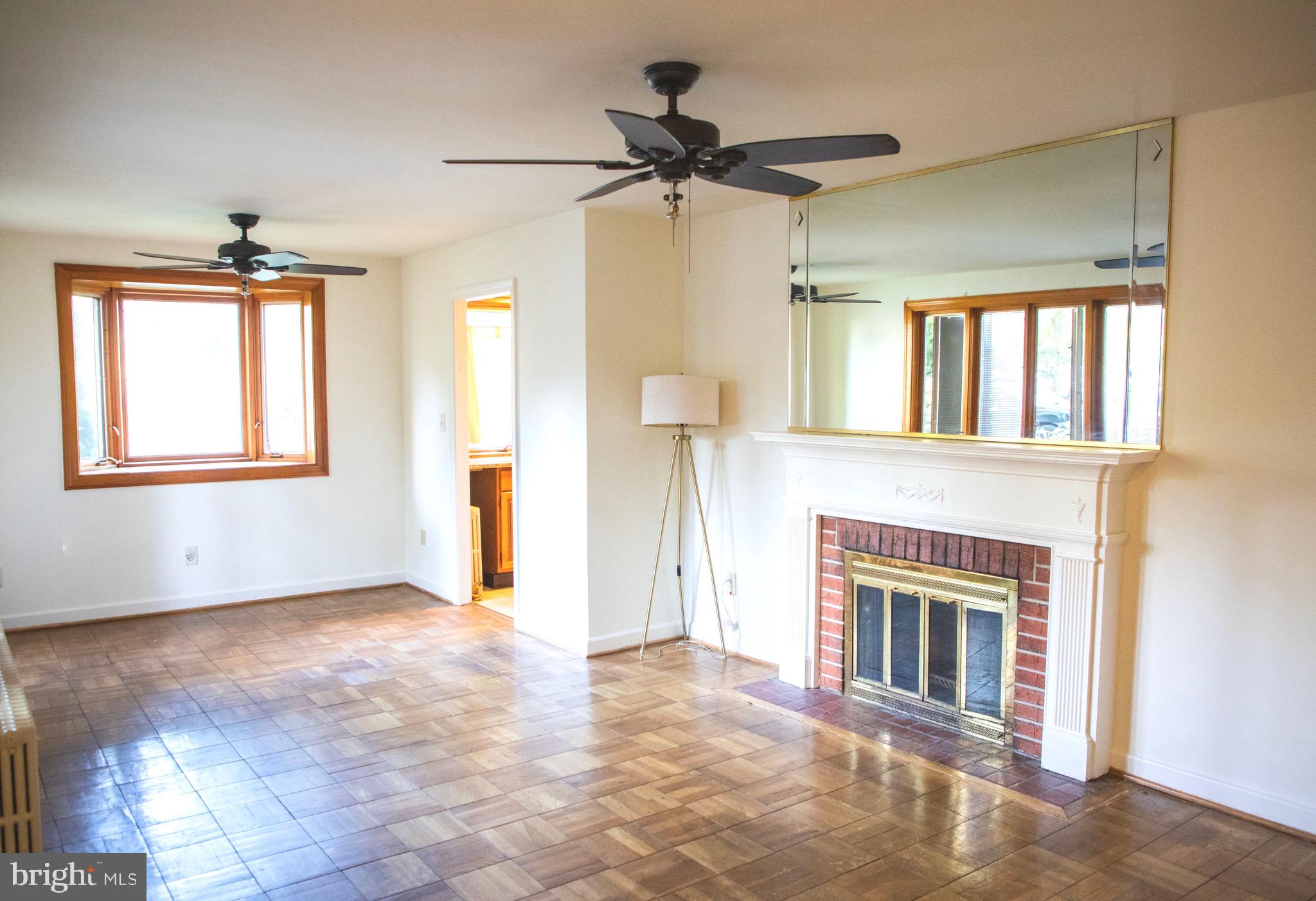 9406 Seminole Street Silver Spring, MD 20901 - Photo 5 of 32 a view of an empty room with a fireplace and a window