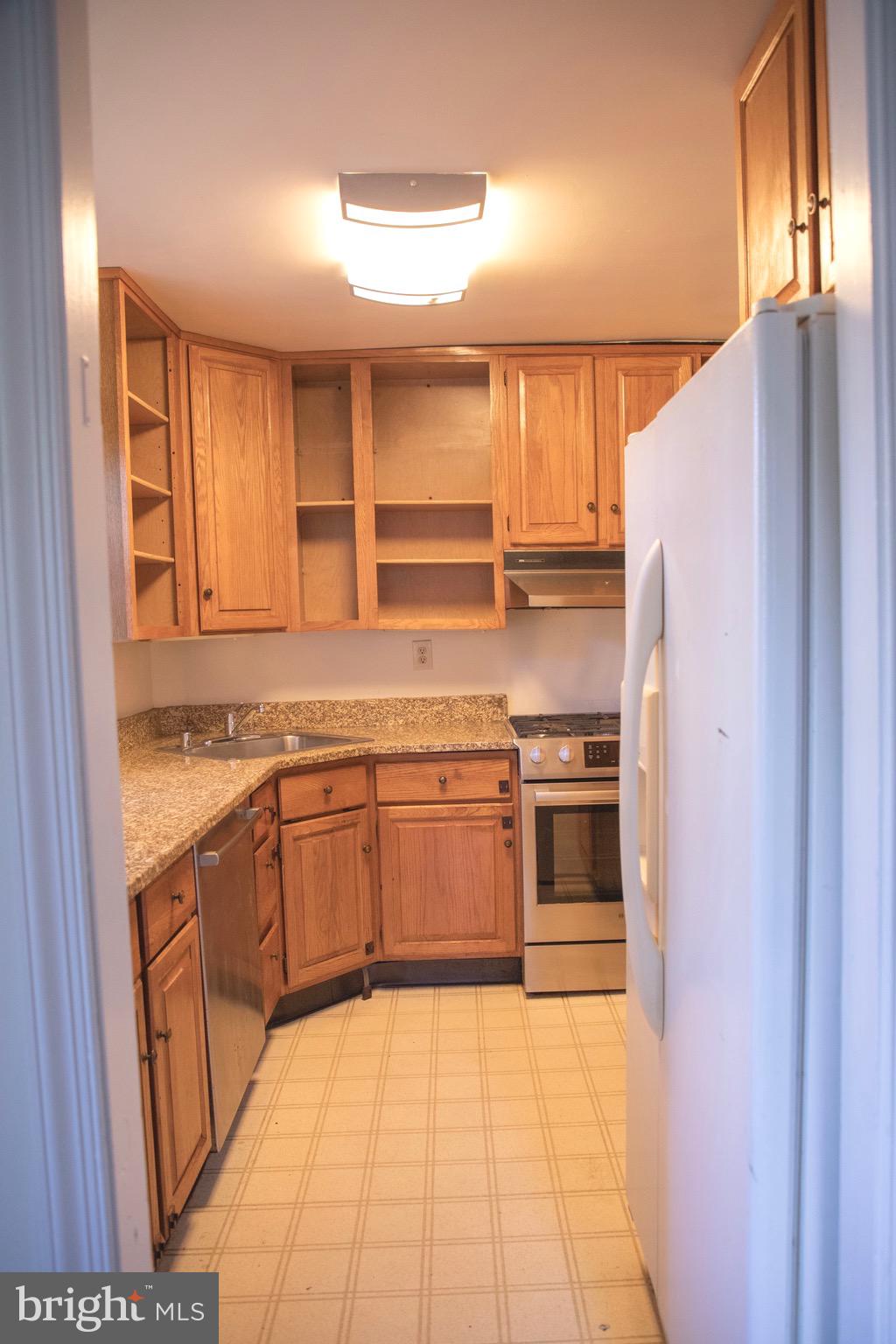 9406 Seminole Street Silver Spring, MD 20901 - Photo 8 of 32 a kitchen with stainless steel appliances granite countertop a stove a sink and a refrigerator