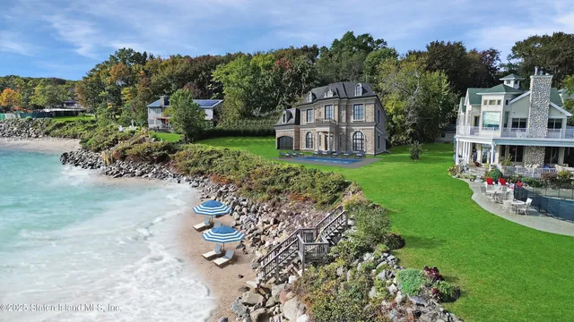 an aerial view of a house with yard and lake view in back