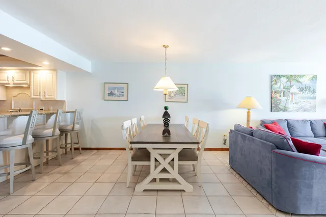 a kitchen with a dining table chairs and refrigerator