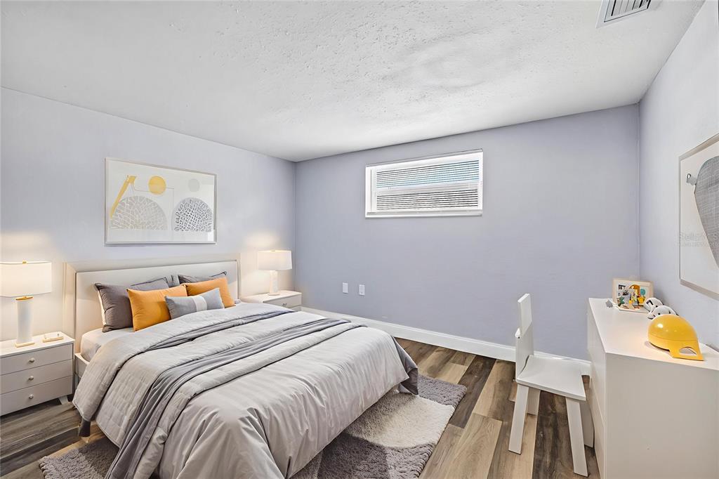 3420 Chickadee Drive Holiday, FL 34690 - Photo 13 of 15 a bedroom with a bed and wooden floor