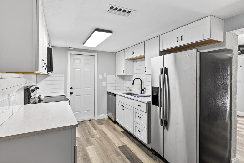 3420 Chickadee Drive Holiday, FL 34690 - Photo 6 of 15 a kitchen with stainless steel appliances a refrigerator sink and cabinets