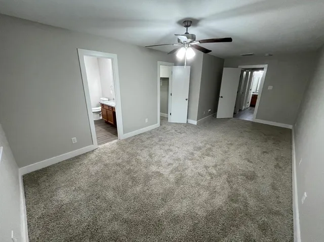 an empty room with closet and chandelier fan
