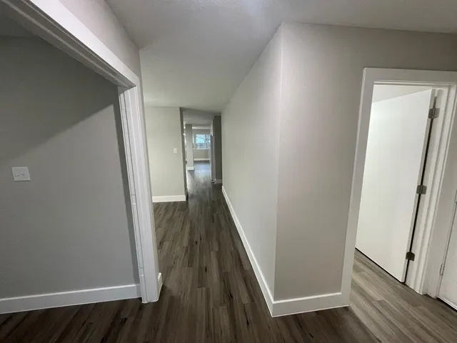 a view of a hallway with wooden floor and staircase