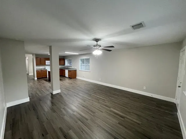 a view of a livingroom with wooden floor and a ceiling fan