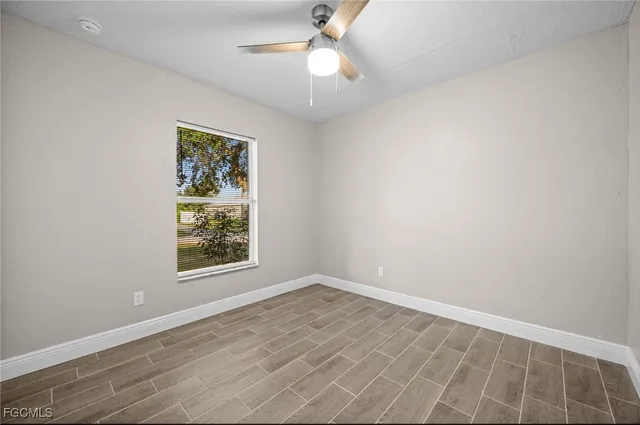 an empty room with a window and a fan