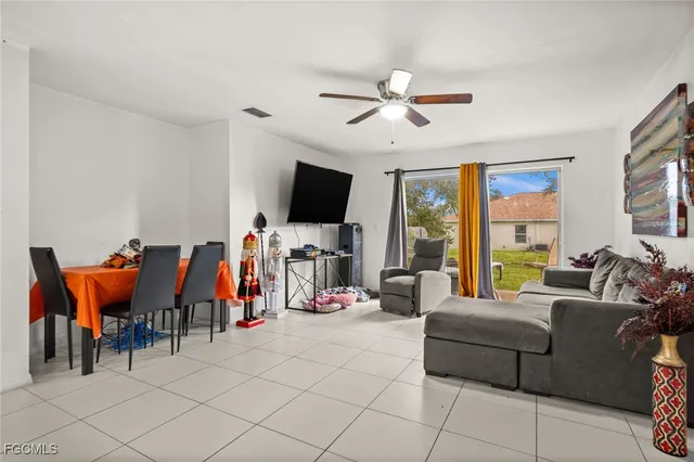 a living room with furniture a flat screen tv and a window