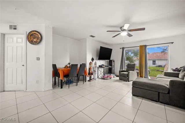 a living room with furniture a flat screen tv and a window