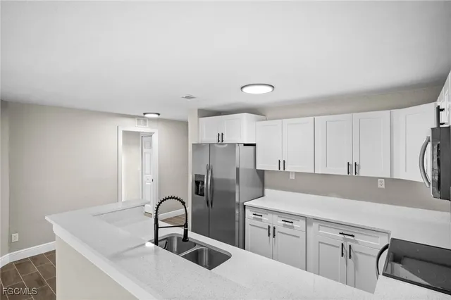 a kitchen with stainless steel appliances granite countertop a sink a stove and refrigerator