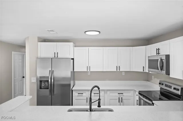 a kitchen with stainless steel appliances granite countertop a refrigerator and a stove