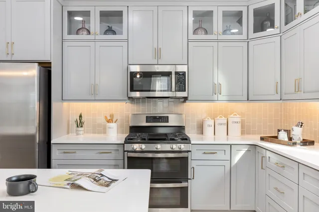 a kitchen with cabinets stainless steel appliances and a counter space