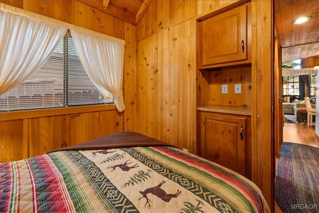 a view of a bedroom with wooden floor and a window