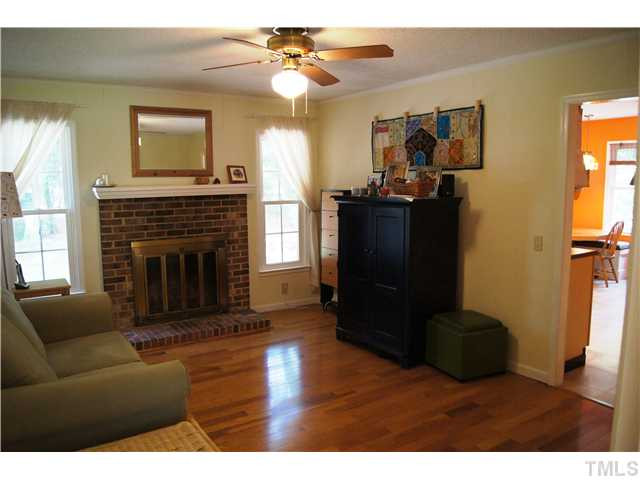 5822 Newhall Road Durham, NC 27713 - Photo 5 of 25 Family room features a Hardwood Floors, a Fireplace, Ceiling Fans. The home also has Vinyl Low-E Argon Windows that are Easy to clean & Tilts on the inside. Den/Family/Great Room