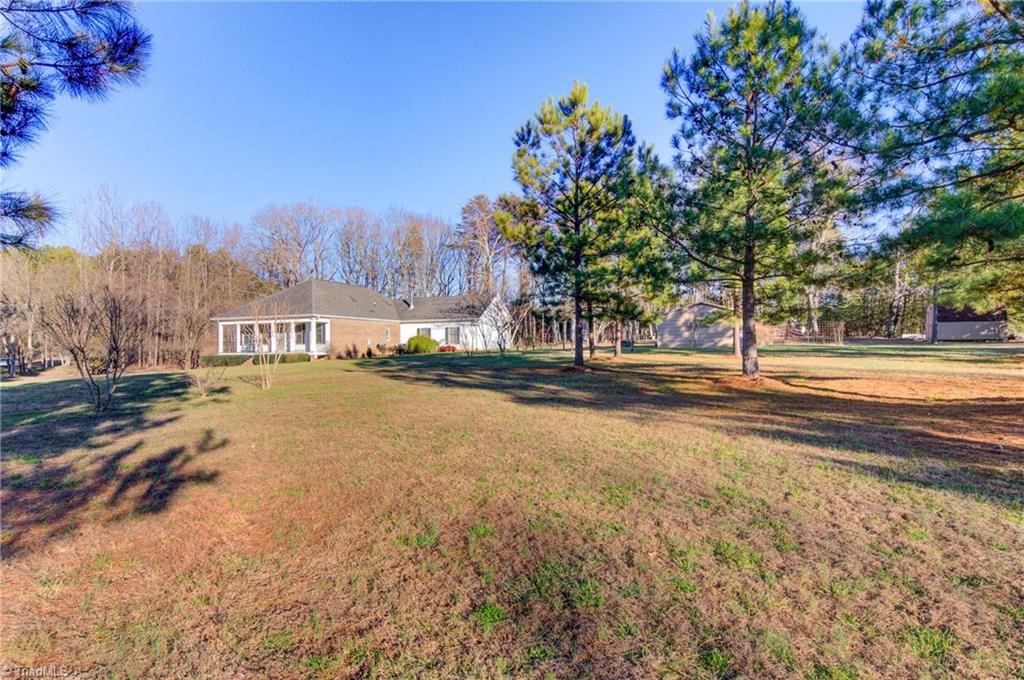 7919 Eric Road Greensboro, NC 27409 - Photo 4 of 34 Privacy at its best. Looking at the house from the front corner of the property. Storage building that remains to the right.