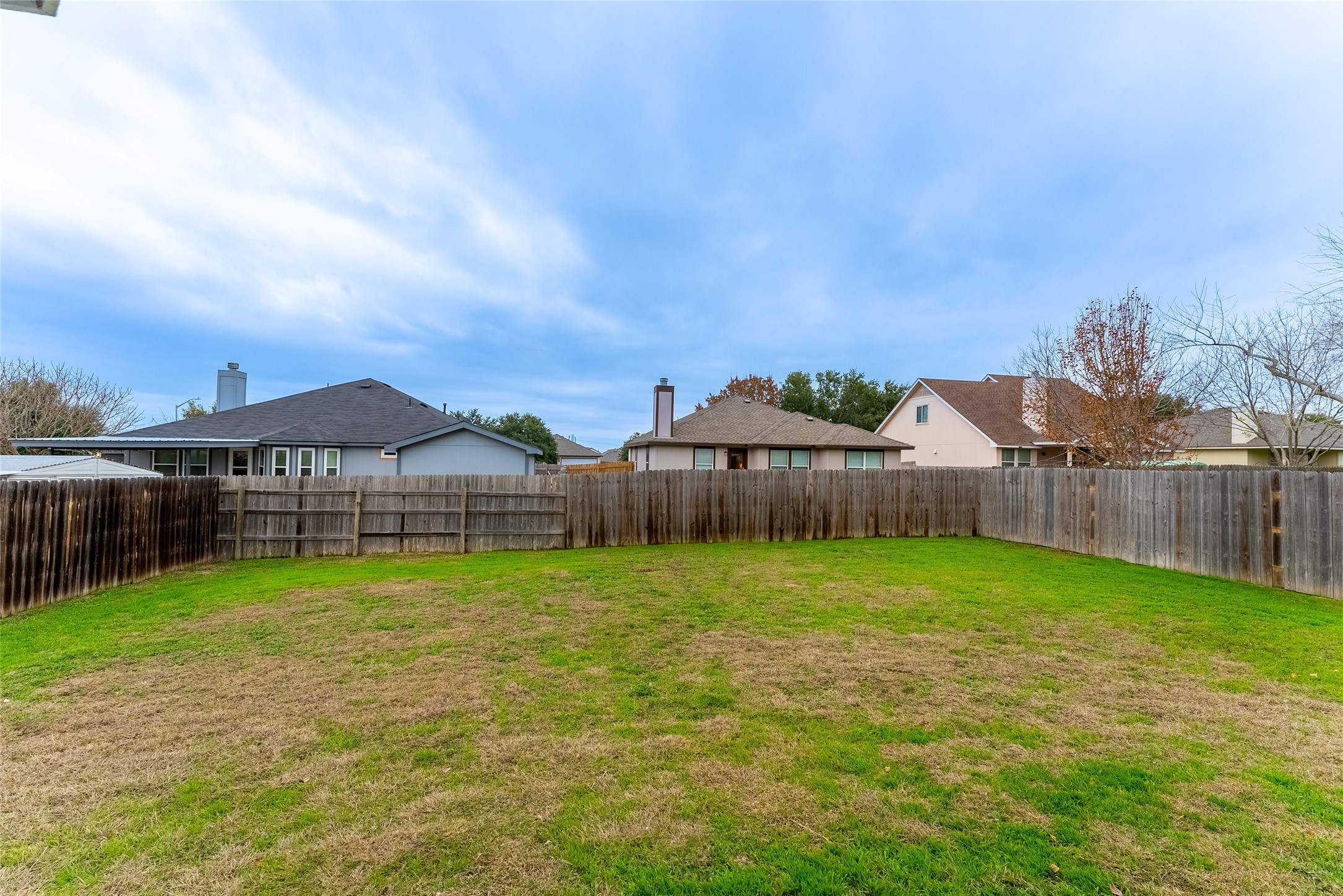 109 Granite Shoals Drive Kyle, TX 78640 - Photo 20 of 22 a view of a backyard with potted plants and wooden fence