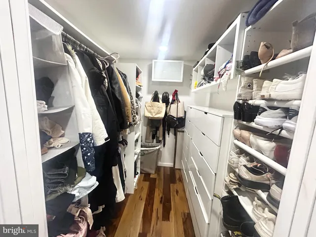 a view of walk in closet with clothes and shoes