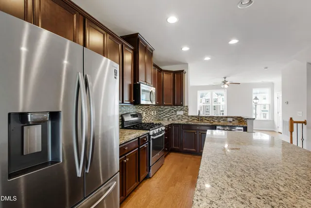 a kitchen with stainless steel appliances granite countertop a stove refrigerator sink and stove