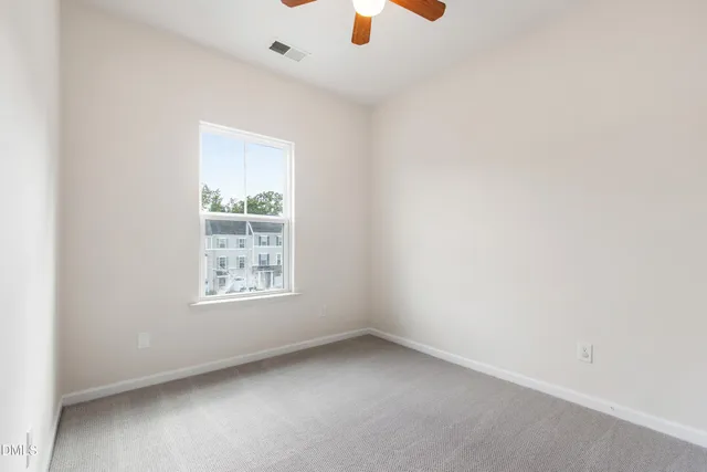 an empty room with a window and a fan