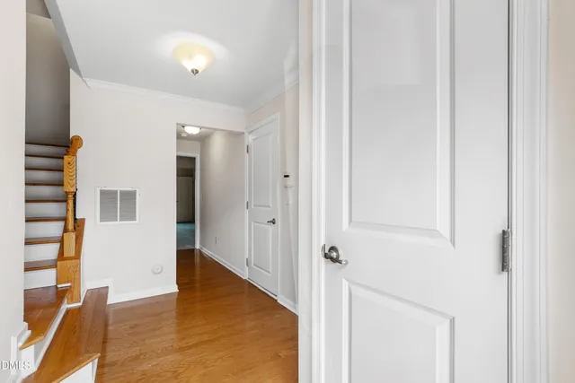a view of a hallway with wooden floor and entryway