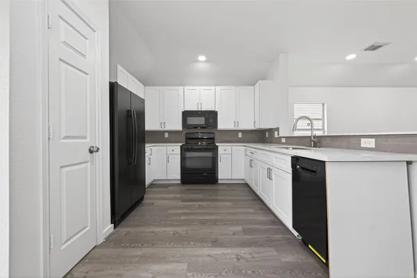 a large kitchen with cabinets stainless steel appliances and a counter space