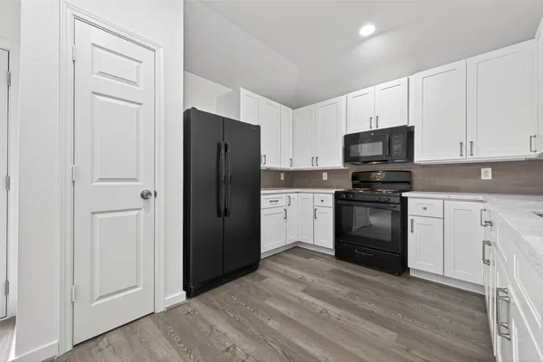 a kitchen with a refrigerator stove and white cabinets