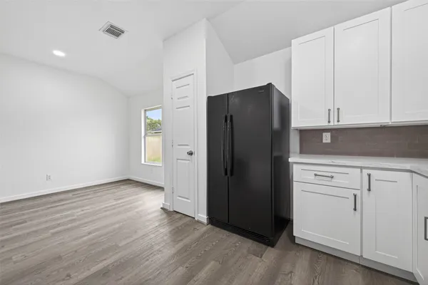 a kitchen with a refrigerator and cabinets