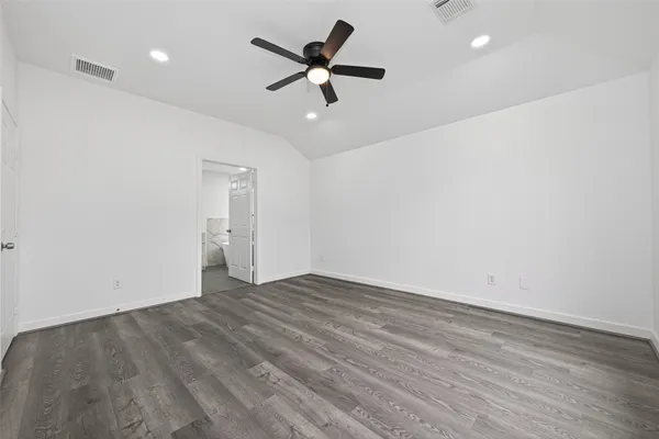 an empty room with a ceiling fan and wooden floor