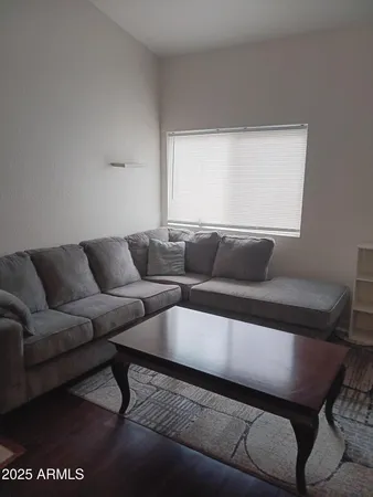 a living room with furniture a rug and a window