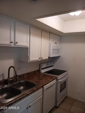 a view of kitchen cabinets and black appliances