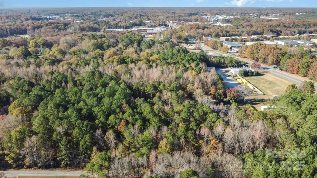 an aerial view of residential houses with outdoor space and trees