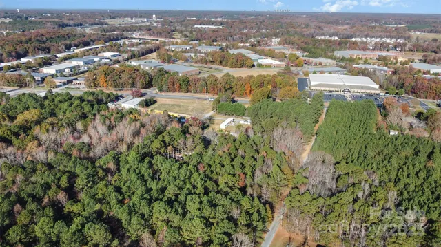 an aerial view of residential houses with outdoor space and trees