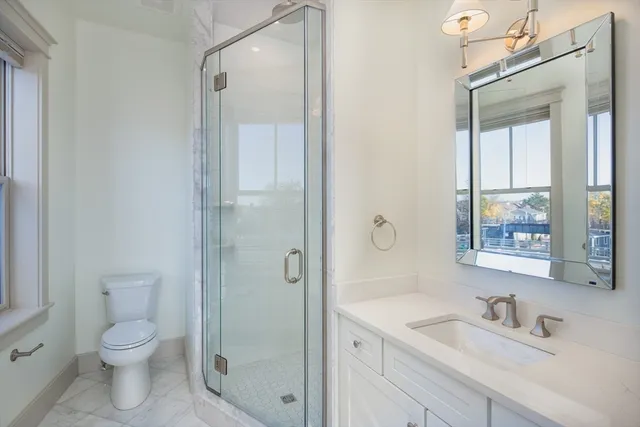 a bathroom with a sink a toilet and shower