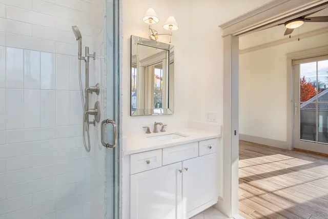 a bathroom with a granite countertop sink a mirror and a shower