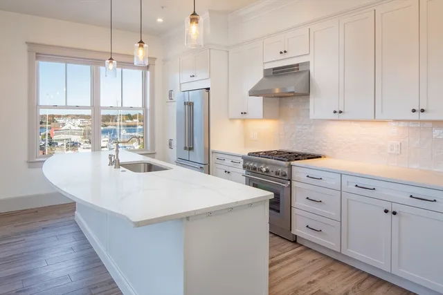 a kitchen with white cabinets and sink