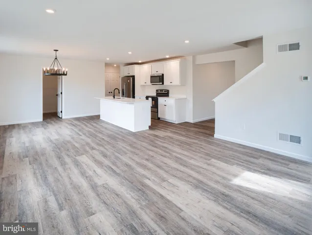 a view of kitchen with wooden floor and electronic appliances
