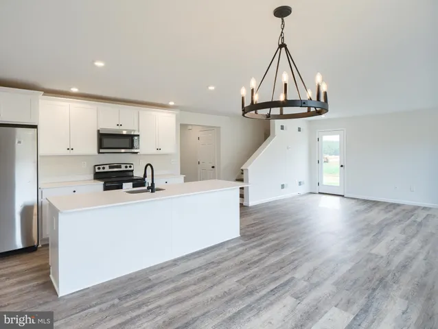 a view of a kitchen with furniture and wooden floor