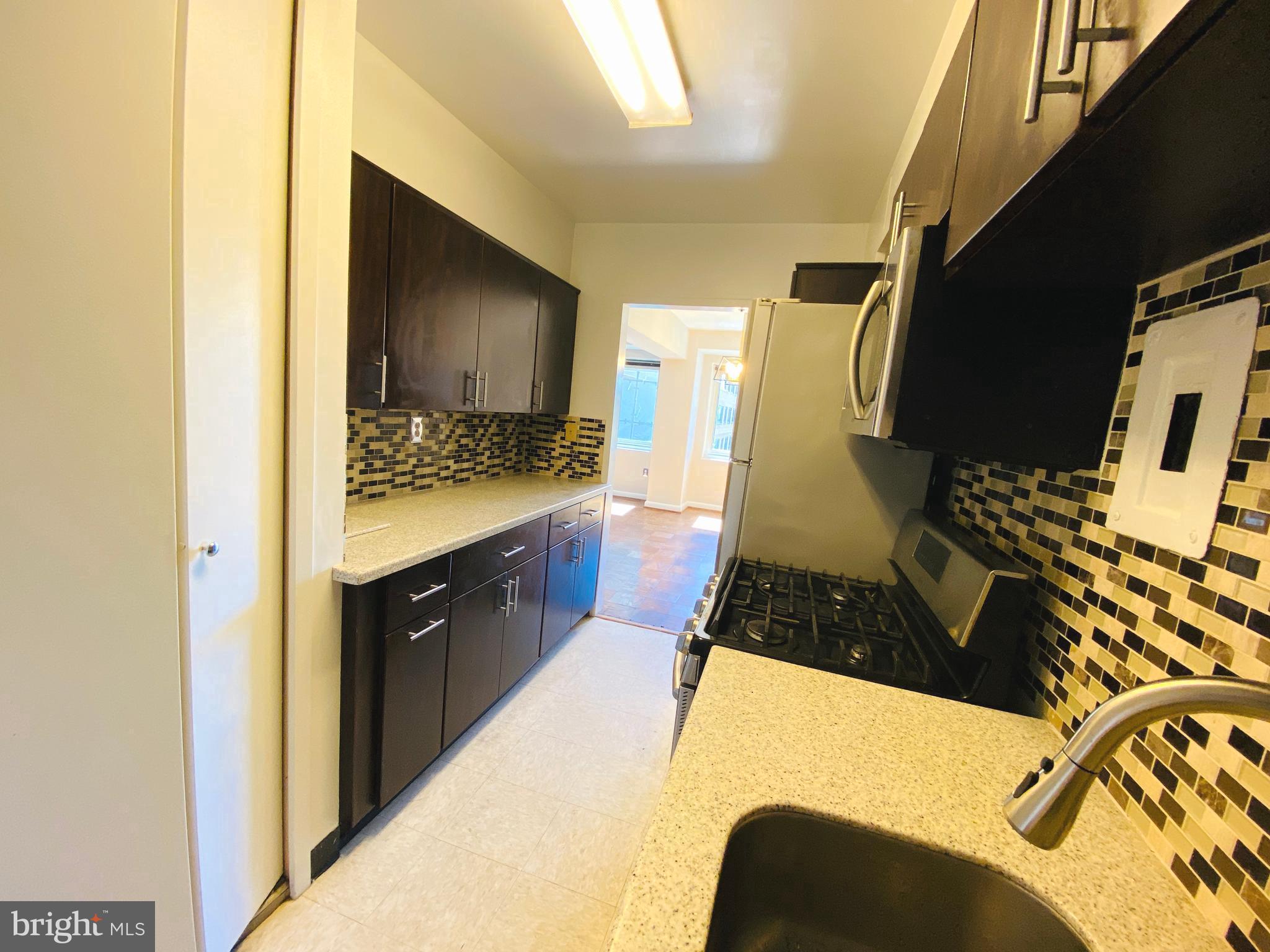 4201 Cathedral Avenue Northwest, Unit 622E Washington, DC 20016 - Photo 11 of 34 a kitchen with a sink a stove and a refrigerator