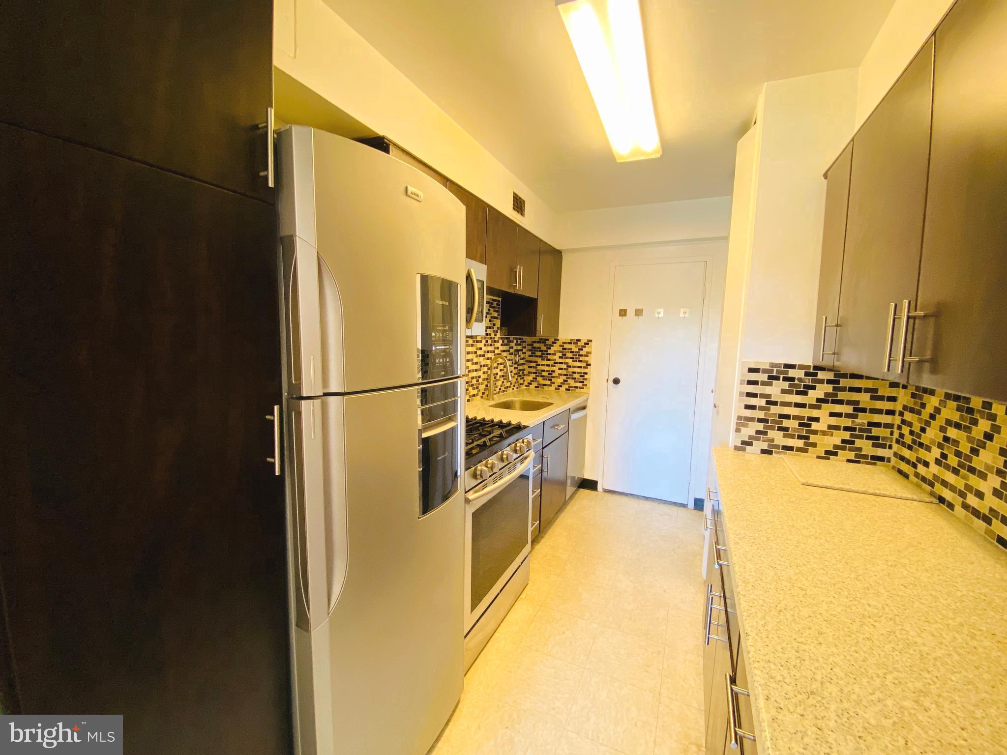 4201 Cathedral Avenue Northwest, Unit 622E Washington, DC 20016 - Photo 13 of 34 a kitchen with a refrigerator and a stove
