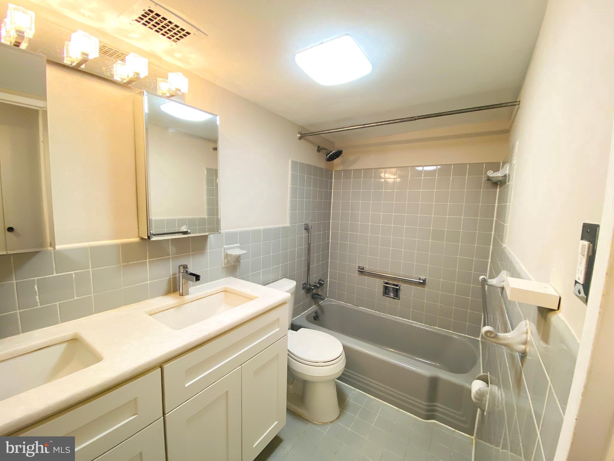 4201 Cathedral Avenue Northwest, Unit 622E Washington, DC 20016 - Photo 22 of 34 a bathroom with a sink a toilet and shower