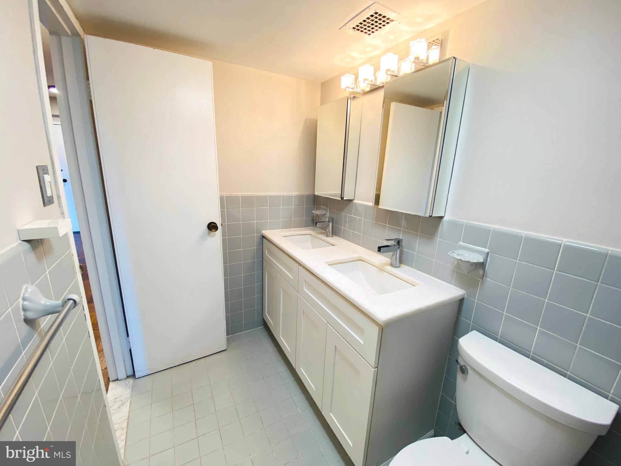 4201 Cathedral Avenue Northwest, Unit 622E Washington, DC 20016 - Photo 23 of 34 a bathroom with a sink a toilet and a mirror