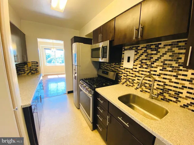 a kitchen with a sink a stove and a refrigerator