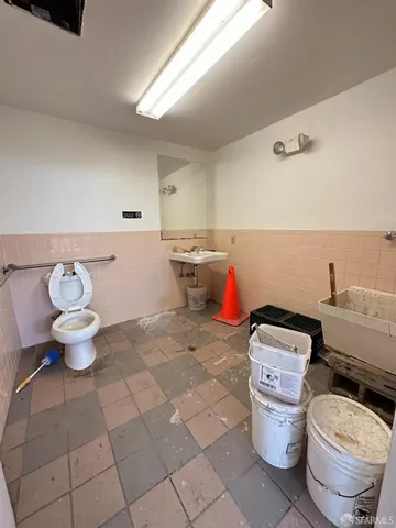 a bathroom with a toilet a sink and a mirror