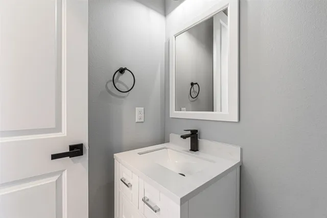 a bathroom with a toilet sink vanity and mirror